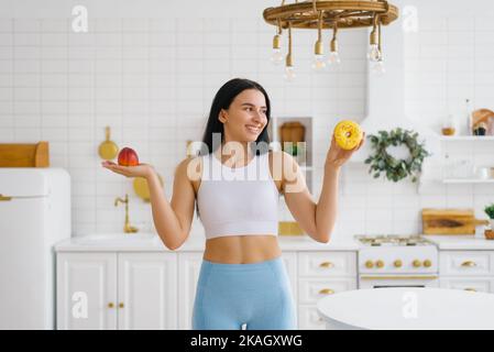 Die junge Frau hat die Wahl zwischen einer Pfirsichfrucht und einem Donut. Das Konzept der Ernährung und gesunde Ernährung Stockfoto