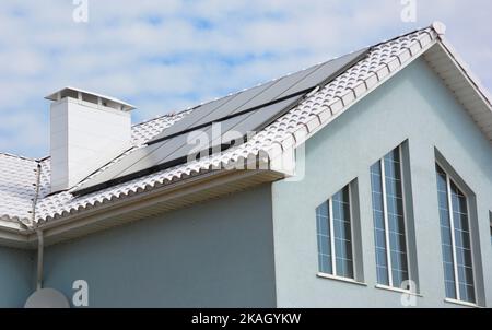 Weißes Dachhaus zur Energieeinsparung. Nahaufnahme eines modernen weißen Hausdachs mit Solarwasserheizpaneelen zur Energieeffizienz. Weiße Dachbeschichtungen. Stockfoto