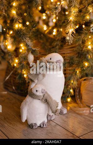 Spielzeug Pinguine unter einem Weihnachtsbaum mit Lichtern Stockfoto