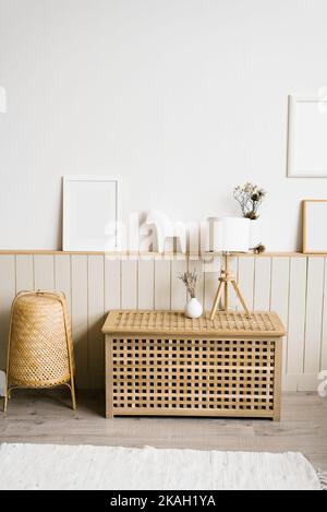 Tischlampe, Lavendel in einer weißen Vase im Dekor des Wohnzimmers in einem minimalistischen skandinavischen Stil. Mockup Rahmen an der Wand in einem gemütlichen Haus inte Stockfoto