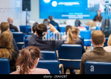 Weicher Fokus von anonymen Zuschauern, die die Präsentation während der Geschäftskonferenz in einem modernen Saal beobachten Stockfoto