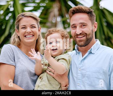 Familie, Baby und Spaß für Liebe, Bindung und Pflege im Garten draußen. Glückliche Eltern, die sich mit ihrem Sohn im Park mit Liebe, Fürsorge und Zuneigung verbinden Stockfoto