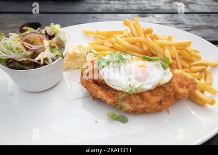Lord Stones Café Mittagessen Huhn Mailanese mit Pommes frites coleslaw und mischt Blätter Salat mit einem Spiegelei auf der Oberseite