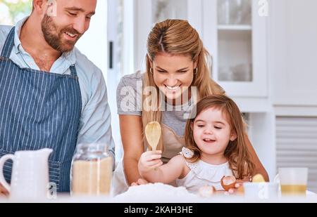 Kochen, Familie und Backwaren in der Küche mit Kind lernen, helfen und glücklich mit Lächeln. Familie zu Hause, Mutter und Vater lehren junge Kind Backen Stockfoto