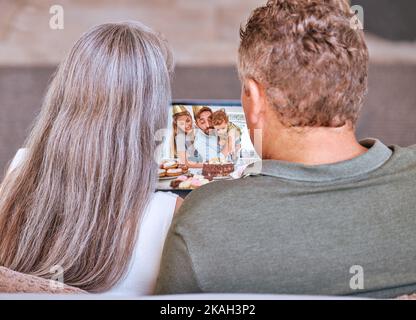 Videoanruf und Seniorenpaar, das den Geburtstag eines Enkelkindes bei einem virtuellen Anruf online feiert. Reife Männer und Frauen feiern Familiengeburtstag mit Video Stockfoto