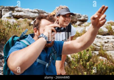 Paare, Ferngläser und Wanderungen in den Bergen und genießen Aussicht, Bewegung und Fitness in der Natur während des Trekkings. Freiheit, Rock und Frau mit ma, Rucksack und Stockfoto