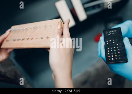 Junge Frau macht Ohrpiercing im Schönheitssalon Stockfoto