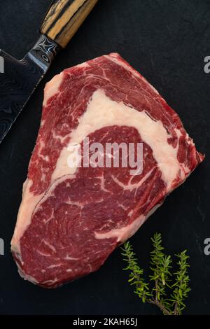 Wagyu Beef Ribeye Steak Raw Dry Aged auf schwarzem Hintergrund Stockfoto