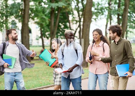 Eine Gruppe von glücklichen Studenten, die durch den Park spazieren. Stockfoto