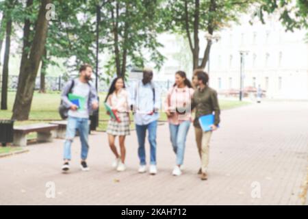 Verschwommenes Bild von Studenten, die nach Vorlesungen durch den Park gehen. Stockfoto
