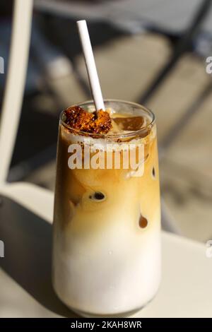 Dalgona Kaffee. Eiskaffeegetränk mit Zucker und Milch auf einer Glastasse auf einem Tisch in einem Café. Trendige kalte Getränke, koreanisches Speisekonzept. Hochwertige Fotos Stockfoto