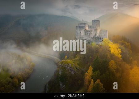 Schlösser der Slowakei: Aus der Vogelperspektive auf die Burg Strecno. Dramatischer Blick auf das Schloss in der herbstlichen Bergwelt. Stockfoto