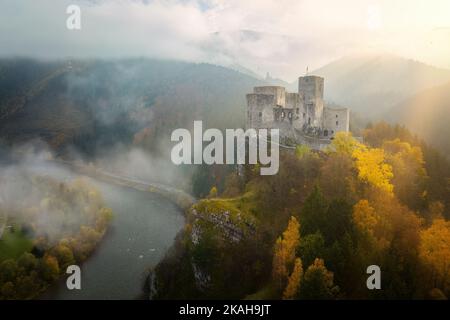 Schlösser der Slowakei: Aus der Vogelperspektive auf die Burg Strecno. Dramatischer Blick auf das Schloss in der herbstlichen Bergwelt. Stockfoto