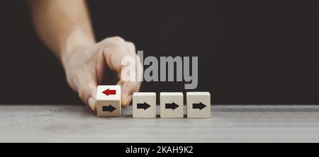 Hand kippen Holzwürfelblock Pfeil von links nach rechts für Geschäftsunterbrechungen und andere Denkansätze. Stockfoto