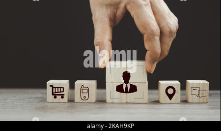 Senior Businessman's Hand complete Crop Icon, Menschen im Inneren auf Holzwürfel für Käufer Persona und Zielkundenkonzept. Käufer- oder Kundenpsychologie p Stockfoto