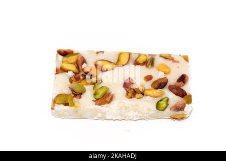 Ein Stück weiche Kokosnuss ägyptischen Süßigkeiten mit Pistazien bedeckt, ägyptische kulturelle Desserts des Propheten Muhammad Geburt Feier (mallid halawa), fest Stockfoto