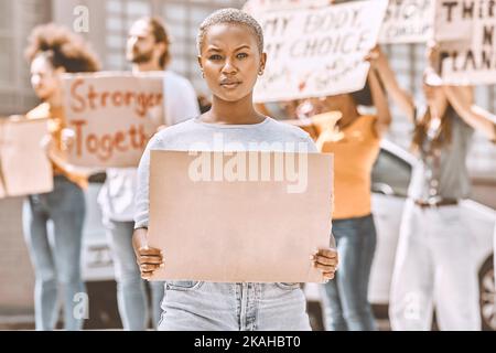 Protestieren, unterschreiben und mockup mit einer schwarzen Aktivistin, die während einer Kundgebung oder Demonstration Karton in der Hand hält. Plakat, Freiheit und Politik mit einem Jungen Stockfoto