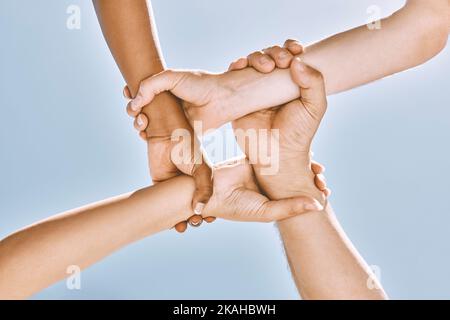 Handgelenkshänden, Teamarbeit und Vielfalt, Unterstützung oder Gemeinschaft, Vertrauen oder Zusammenarbeit am blauen Himmel. Zusammenarbeit, Mitarbeiter, die Waffen halten oder motiviert sind Stockfoto