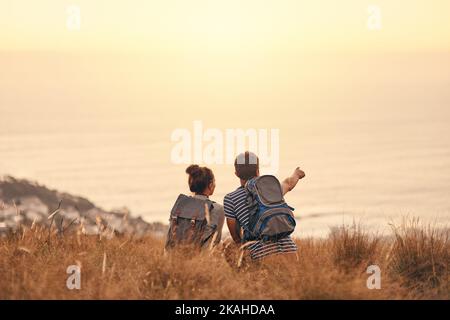 Blick auf die Schönheit über dem Horizont. Rückansicht eines Paares, das nach dem Wandern eine Pause einnahm. Stockfoto