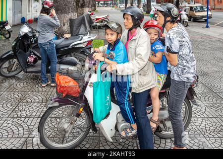 Vietnamesische vierköpfige Familie mit Helmen auf dem Motorrad, Ho Chi Minh City, Vietnam Stockfoto