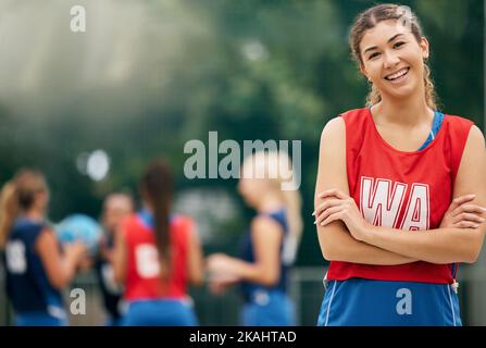 Stolze, Sport- und Netball-Frau im Portrait lächelt für Erfolg, Trainingsmotivation und Outdoor-Wellness-Herausforderung mit Team. Jung, glücklich und gesund Stockfoto