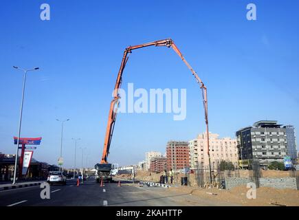 Kairo, Ägypten, Oktober 3 2022: Eine LKW-montierte Betonauslegerpumpe am Straßenrand, die Beton in ein neues Gebäude gießt, selektiver Fokus von concre Stockfoto