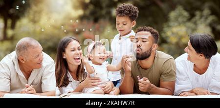 Glücklich, lächelnd und große Familie bläst Blasen in einem Garten auf einem Sommer-Picknick in Puerto Rico. Glück, Großeltern und Eltern mit spielenden Kindern Stockfoto