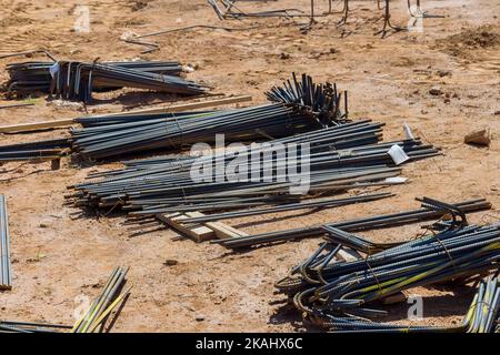 Bei der Montage von Stahlbetongebäuden auf der Baustelle werden Stahlstäbe zur Verstärkung von Beton verwendet Stockfoto