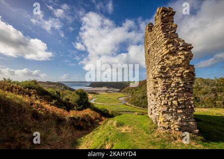 Teil der zerstörten Außenmauer von Pennard Castle mit Blick auf Three Cliffs Bay, Gower Peninsula, Wales Stockfoto