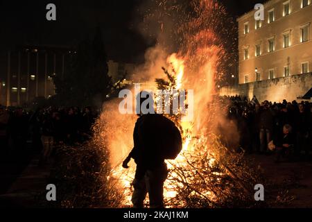 Während eines Protestes gegen die Rentenreform haben Bauern vor dem Parlamentsgebäude am Syntagma-Platz Feuer angezündet. Griechische Bauern aus dem ganzen Land reiste nach Athen am Freitag, den 12,2016. Februar, um eine zweitägige Protest vor dem Parlament gegen die governmentâ €™s Pläne zu verhängen Steuererhöhungen und Rentenreform. (Foto von Chrissa Giannakoudi/NurPhoto) *** Bitte nutzen Sie die Gutschrift aus dem Kreditfeld *** Stockfoto