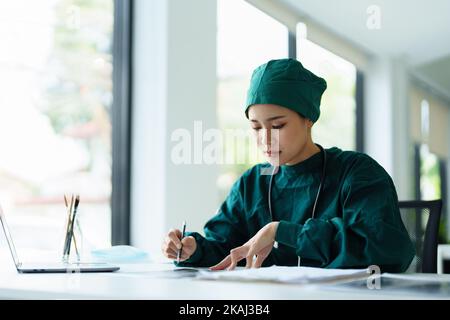 Porträt eines asiatischen Arztes, der den Röntgenfilm des Patienten betrachtet..Porträt eines asiatischen Arztes, der den Röntgenfilm des Patienten betrachtet. Stockfoto