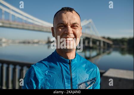 Porträt eines lächelnden Sportlers mit nassem Gesicht Stockfoto