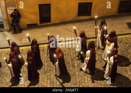 SANTANDER.SPAIN 24. MARCH 2016 Nazarener der Bruderschaft des Heiligen Christus des Friedens durch die Straßen von Santander zünden ihre Kerzen in der Nacht des Gründonnerstags an Stockfoto