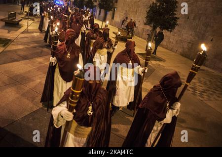 SANTANDER.SPAIN 24. MARCH 2016 Nazarener der Bruderschaft des Heiligen Christus des Friedens durch die Straßen von Santander zünden ihre Kerzen in der Nacht des Gründonnerstags an Stockfoto