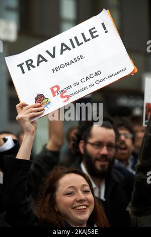 In Geschäftsleuten verkleidete Demonstranten halten ein Plakat mit der Aufschrift „Arbeit faul!“ Während einer massiven Demonstration gegen das El-Khomri-Gesetz über Arbeitsreformen. März 31. 2016. Toulouse. Frankreich. (Foto von Alain Pitton/NurPhoto) *** Bitte nutzen Sie die Gutschrift aus dem Kreditfeld *** Stockfoto