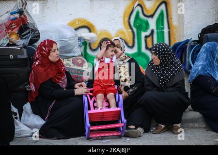 Ein Kind wartete mit seiner Familie auf eine Reisegenehmigung für die Überfahrt nach Ägypten über den Grenzübergang Rafah, der der einzige Zugang zum Gazastreifen nach außen ist, nachdem die ägyptischen Behörden am 12. Mai 2016 in zwei Richtungen in Gaza-Stadt, Gaza, wiedereröffnet hatten. Studenten, Patienten, Personen mit Aufenthaltstitel und Passinhabern dürfen die Grenze überqueren. Stockfoto