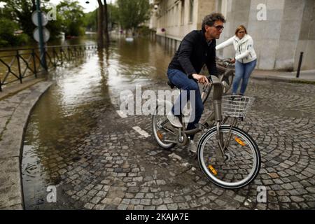 Die Menschen machen Fotos und beobachten, wie das Wasser in der Nähe des Eiffelturms aufsteigt, während die Böschungen des Flusses seine nach vier Tagen starken Regens am 3. Juni 2016 in Paris, Frankreich, überströmen. Nordfrankreich erlebt derzeit Regenwetter und verursacht Überschwemmungen in Teilen Frankreichs, insbesondere in Paris, wo die French Open Verzögerungen bei den Spielen hatten. (Foto von Mehdi Taamallah/NurPhoto) *** Bitte benutzen Sie die Gutschrift aus dem Kreditfeld *** Stockfoto