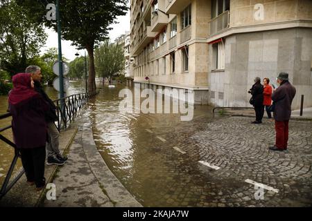 Die Menschen machen Fotos und beobachten, wie das Wasser in der Nähe des Eiffelturms aufsteigt, während die Böschungen des Flusses seine nach vier Tagen starken Regens am 3. Juni 2016 in Paris, Frankreich, überströmen. Nordfrankreich erlebt derzeit Regenwetter und verursacht Überschwemmungen in Teilen Frankreichs, insbesondere in Paris, wo die French Open Verzögerungen bei den Spielen hatten. (Foto von Mehdi Taamallah/NurPhoto) *** Bitte benutzen Sie die Gutschrift aus dem Kreditfeld *** Stockfoto