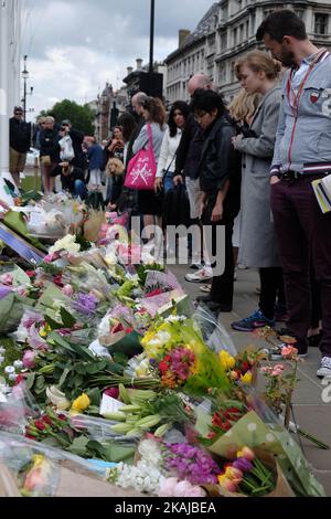 Die Menschen verlassen Floral Tributes, als sie an einer Mahnwache zum Gedenken an den Labour-Abgeordneten Jo Cox vor dem Westminster Palace am 17. Juni 2016 in London, England, teilnehmen. Die Labour-Abgeordnete für Batley und Spen wollte gestern in der Birstall-Bibliothek ihre wöchentliche Wahlkreisoperation abhalten, als sie am 16. Juni auf der Straße angeschossen und erstochen wurde. Ein 52-jähriger Mann wird wegen des Todes in Polizeigewahrsam gehalten. (Foto von Jay Shaw Baker/NurPhoto) *** Bitte nutzen Sie die Gutschrift aus dem Kreditfeld *** Stockfoto