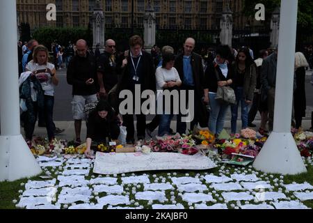 Die Menschen verlassen Floral Tributes, als sie an einer Mahnwache zum Gedenken an den Labour-Abgeordneten Jo Cox vor dem Westminster Palace am 17. Juni 2016 in London, England, teilnehmen. Die Labour-Abgeordnete für Batley und Spen wollte gestern in der Birstall-Bibliothek ihre wöchentliche Wahlkreisoperation abhalten, als sie am 16. Juni auf der Straße angeschossen und erstochen wurde. Ein 52-jähriger Mann wird wegen des Todes in Polizeigewahrsam gehalten. (Foto von Jay Shaw Baker/NurPhoto) *** Bitte nutzen Sie die Gutschrift aus dem Kreditfeld *** Stockfoto