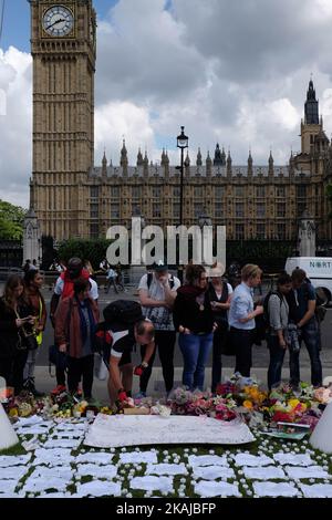 Die Menschen verlassen Floral Tributes, als sie an einer Mahnwache zum Gedenken an den Labour-Abgeordneten Jo Cox vor dem Westminster Palace am 17. Juni 2016 in London, England, teilnehmen. Die Labour-Abgeordnete für Batley und Spen wollte gestern in der Birstall-Bibliothek ihre wöchentliche Wahlkreisoperation abhalten, als sie am 16. Juni auf der Straße angeschossen und erstochen wurde. Ein 52-jähriger Mann wird wegen des Todes in Polizeigewahrsam gehalten. (Foto von Jay Shaw Baker/NurPhoto) *** Bitte nutzen Sie die Gutschrift aus dem Kreditfeld *** Stockfoto