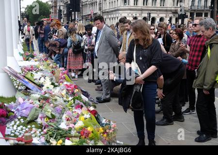 Die Menschen verlassen Floral Tributes, als sie an einer Mahnwache zum Gedenken an den Labour-Abgeordneten Jo Cox vor dem Westminster Palace am 17. Juni 2016 in London, England, teilnehmen. Die Labour-Abgeordnete für Batley und Spen wollte gestern in der Birstall-Bibliothek ihre wöchentliche Wahlkreisoperation abhalten, als sie am 16. Juni auf der Straße angeschossen und erstochen wurde. Ein 52-jähriger Mann wird wegen des Todes in Polizeigewahrsam gehalten. (Foto von Jay Shaw Baker/NurPhoto) *** Bitte nutzen Sie die Gutschrift aus dem Kreditfeld *** Stockfoto