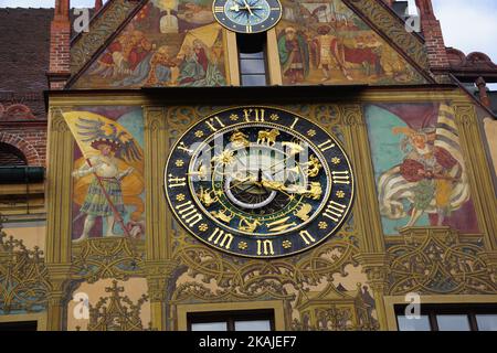 Ein schöner Blick auf den Uhrenturm des Ulmer Rathauses in Deutschland mit heraldischen Symbolen und Wandmalereien an der Wand Stockfoto