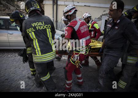 Retter tragen einen Mann aus den Trümmern, nachdem am 24. August 2016 ein starkes Erdbeben Amatrice getroffen hatte. Mittelitalien wurde von einem starken Erdbeben der Stärke 6,2 in den frühen Morgenstunden getroffen, bei dem mindestens drei Menschen ums Leben kamen und Dutzende von Bergdörfern verwüstet wurden. Zahlreiche Gebäude seien in Gemeinden in der Nähe des Epizentrum des Bebens in der Nähe der Stadt Norcia in der Region Umbrien zusammengebrochen, berichteten Zeugen italienischen Medien, mit einer Erhöhung der Todesrate sehr wahrscheinlich. Stockfoto