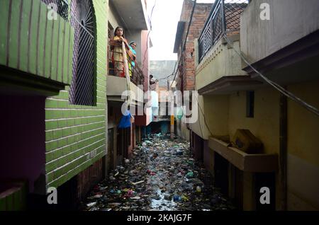 Indische Bewohner von überfluteten Gebieten stehen auf ihrem Balkon, um Materialien für den täglichen Bedarf zu erhalten, da am 26,2016. August in Allahabad im überfluteten Wasser Müll und Abfall auftaucht.das Elend hat sich etwas entspannt, da die Regenfälle in den letzten drei Tagen im Bundesstaat Uttar Pradesh abnahmen. Dort waren 200.000 Menschen nach dem Eintauchen in ihre Häuser in Hilfszentren umgezogen, sagte Deepak Singhal, ein Staatsbeamter. Hubschrauber der Luftwaffe warfen Nahrungsmittelpakete an Tausende von Menschen im Allahabad-Bezirk ab, die es vorzogen, in den oberen Stockwerken ihrer überfluteten Häuser zu bleiben und auf das Absinken des Wassers statt auf m zu warten Stockfoto
