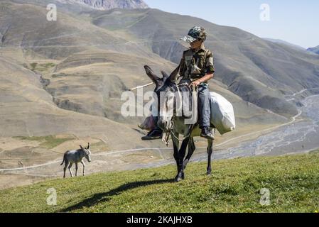 Ein Junge reitet auf einem Esel auf dem Weg zum Lager der Hirten in der Nähe des Dorfes Khinalig, Region Quba, Aserbaidschan. Während der Sommerferien arbeitet er mit seinem Vater als Hirte. Sie gehen in die Berge, um tagsüber neue Weideplätze für Schafe zu finden und kommen am Abend ins Lager zurück. Eine Hirtenschicht hat eine Dauer von 5 Tagen. ( (Foto von Oleksandr Rupeta/NurPhoto)) *** Bitte nutzen Sie die Gutschrift aus dem Kreditfeld *** Stockfoto