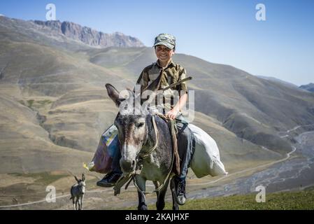 Ein Junge reitet auf einem Esel auf dem Weg zum Lager der Hirten in der Nähe des Dorfes Khinalig, Region Quba, Aserbaidschan. Während der Sommerferien arbeitet er mit seinem Vater als Hirte. Sie gehen in die Berge, um tagsüber neue Weideplätze für Schafe zu finden und kommen am Abend ins Lager zurück. Eine Hirtenschicht hat eine Dauer von 5 Tagen. ( (Foto von Oleksandr Rupeta/NurPhoto)) *** Bitte nutzen Sie die Gutschrift aus dem Kreditfeld *** Stockfoto