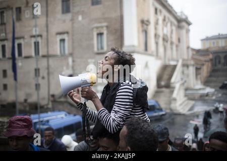 Junge Migranten rufen bei starkem Regen am 11. Oktober 2016 bei einer Demonstration auf dem Campidoglio-Platz auf dem Kapitolinischen Hügel im Zentrum Roms Parolen. Migranten und Freiwillige von "Baobab Experience" fragten nach einem sicheren Ort, an dem Flüchtlinge, hauptsächlich aus dem Horn von Afrika, untergebracht werden könnten.das Baobab-Zentrum wurde im Dezember 2015 von der Polizei nach den Anschlägen von Paris geschlossen. Doch die Baobab-Freiwilligen haben schnell ein Lager auf der Straße vor dem alten Tierheim mit Zelten und chemischen Toiletten eingerichtet, das drei Mahlzeiten am Tag serviert. (Foto von Christian Minelli/NurPhoto) *** Bitte nutzen Sie die Gutschrift von Cre Stockfoto