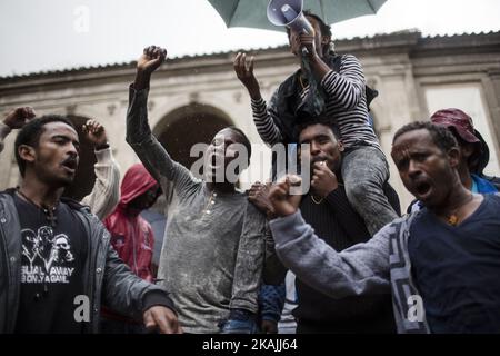 Junge Migranten rufen bei starkem Regen am 11. Oktober 2016 bei einer Demonstration auf dem Campidoglio-Platz auf dem Kapitolinischen Hügel im Zentrum Roms Parolen. Migranten und Freiwillige von "Baobab Experience" fragten nach einem sicheren Ort, an dem Flüchtlinge, hauptsächlich aus dem Horn von Afrika, untergebracht werden könnten.das Baobab-Zentrum wurde im Dezember 2015 von der Polizei nach den Anschlägen von Paris geschlossen. Doch die Baobab-Freiwilligen haben schnell ein Lager auf der Straße vor dem alten Tierheim mit Zelten und chemischen Toiletten eingerichtet, das drei Mahlzeiten am Tag serviert. (Foto von Christian Minelli/NurPhoto) *** Bitte nutzen Sie die Gutschrift von Cre Stockfoto