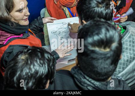 Migranten zeigen auf der Karte im Registrierungszentrum in der Nähe des Calais-Dschungels auf der Karte, wo sie am 25. Oktober 2016 in Calais, Frankreich, verteilt werden wollen. Bis zum Abend wurden etwa 4.000 Migranten aus dem Flüchtlingslager an der Küste des Ärmelkanals in mehrere Regionen Frankreichs verteilt. (Foto von Markus Heine/NurPhoto) *** Bitte nutzen Sie die Gutschrift aus dem Kreditfeld *** Stockfoto